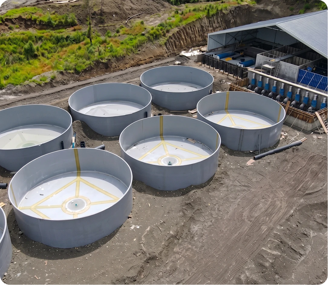 Vista aérea de estanques circulares en construcción junto a una nave RAS